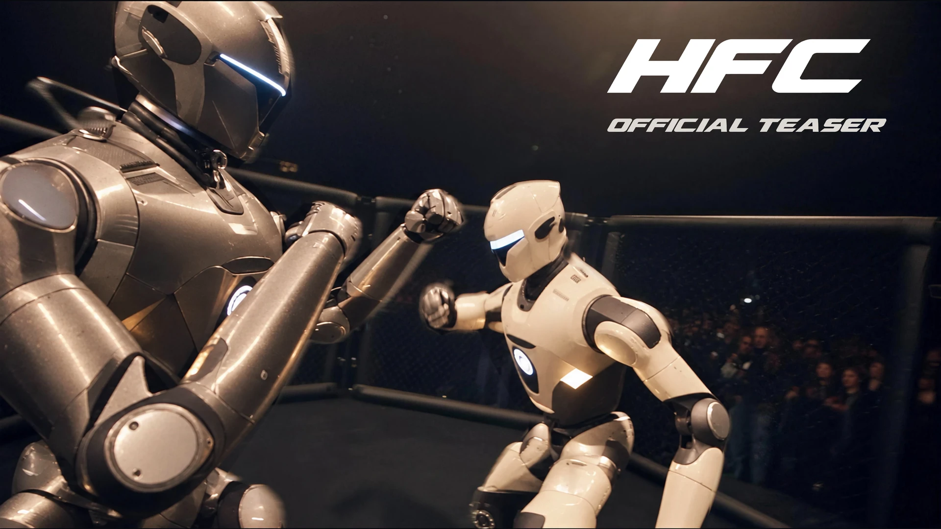 HFC official teaser: a grey machine and a white machine trading punches in a cage, with a crowd behind the mesh